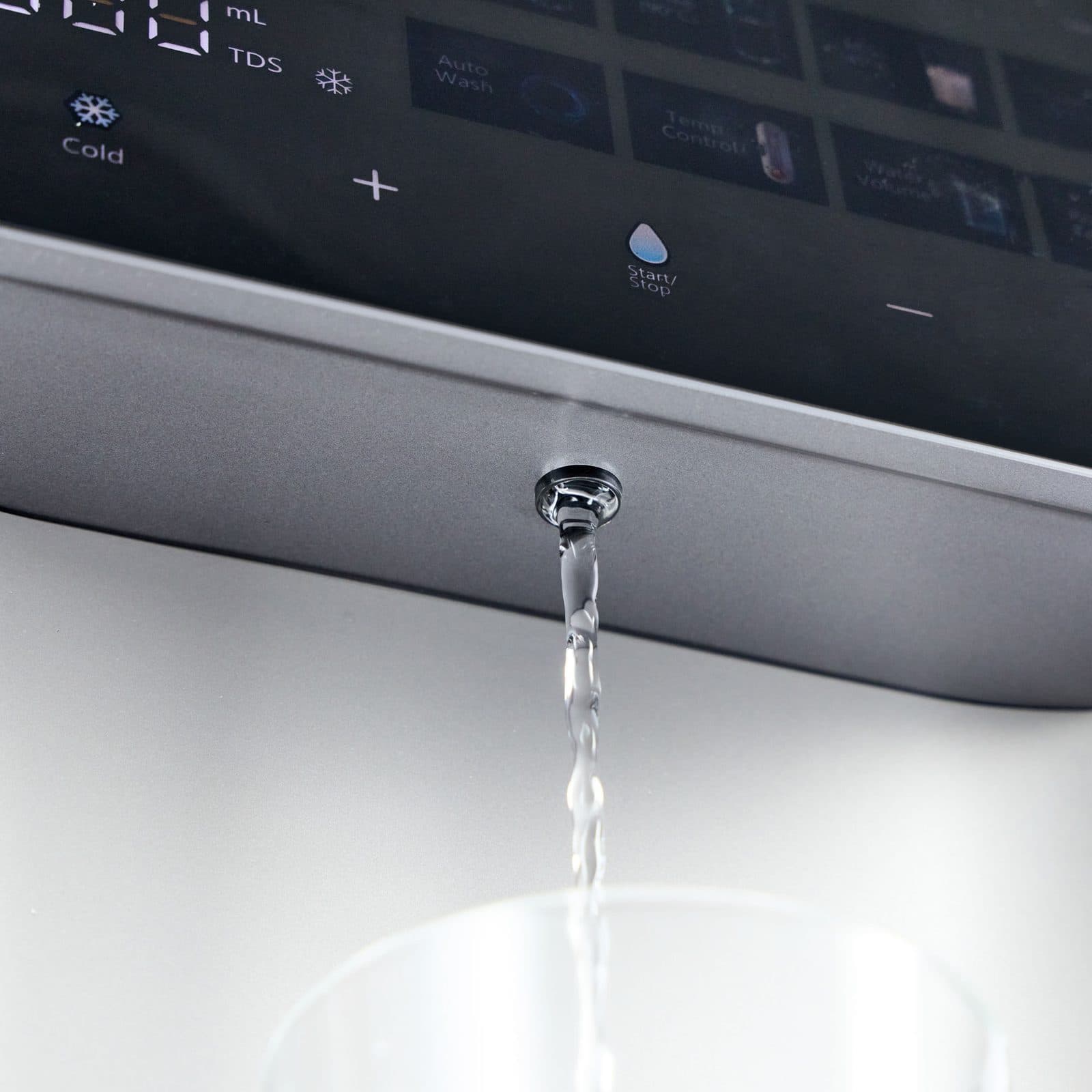 A clear stream of filtered water pouring from the Aqua outlet